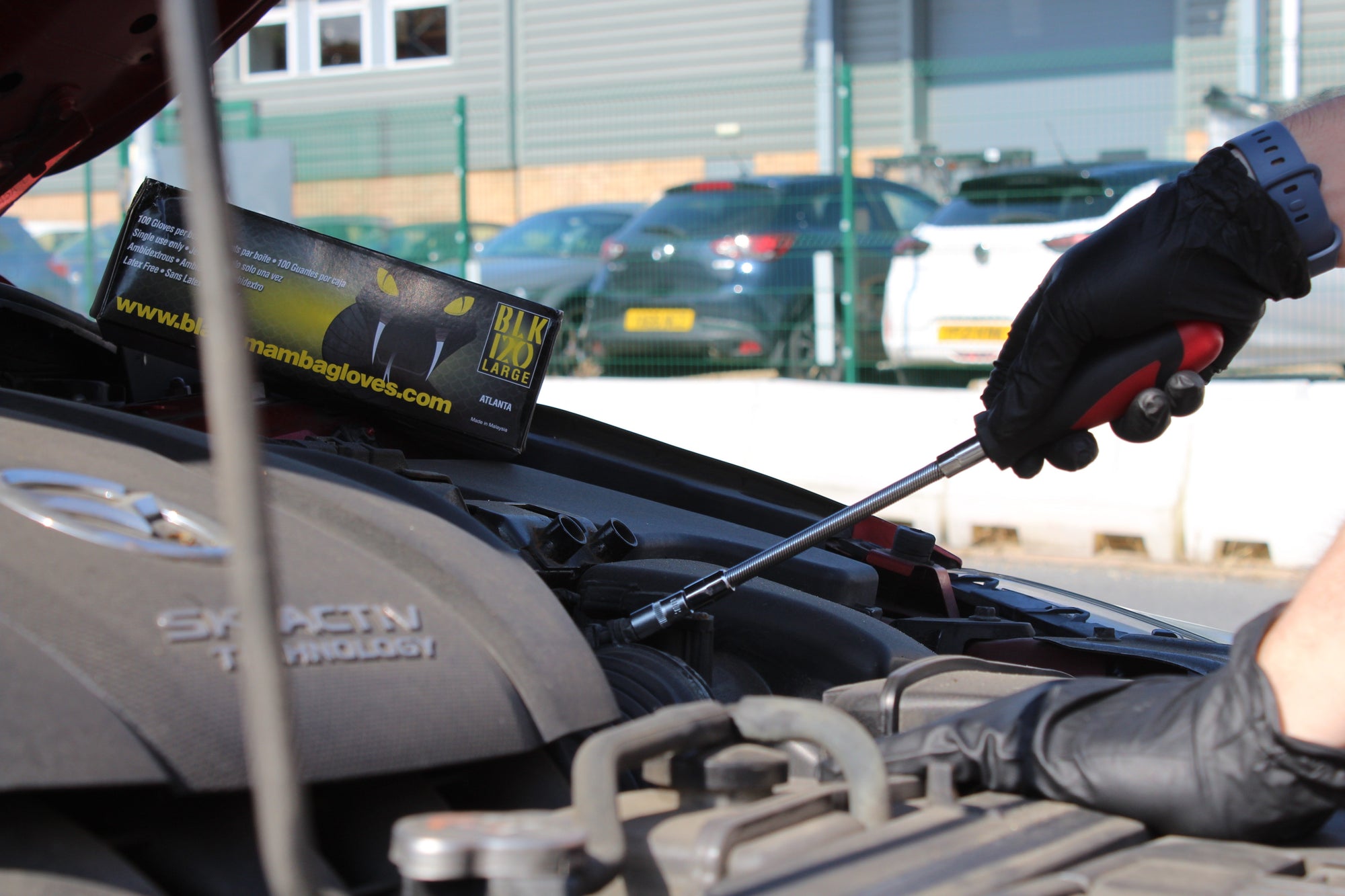 Car Engine with black mamba Glove box with person working on it 